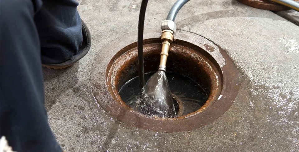 High pressure water jetting clearing a drain